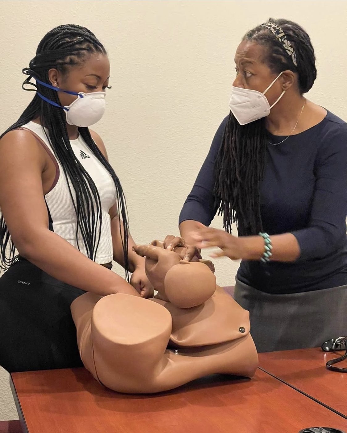 A preceptor teaching a student with a birth model